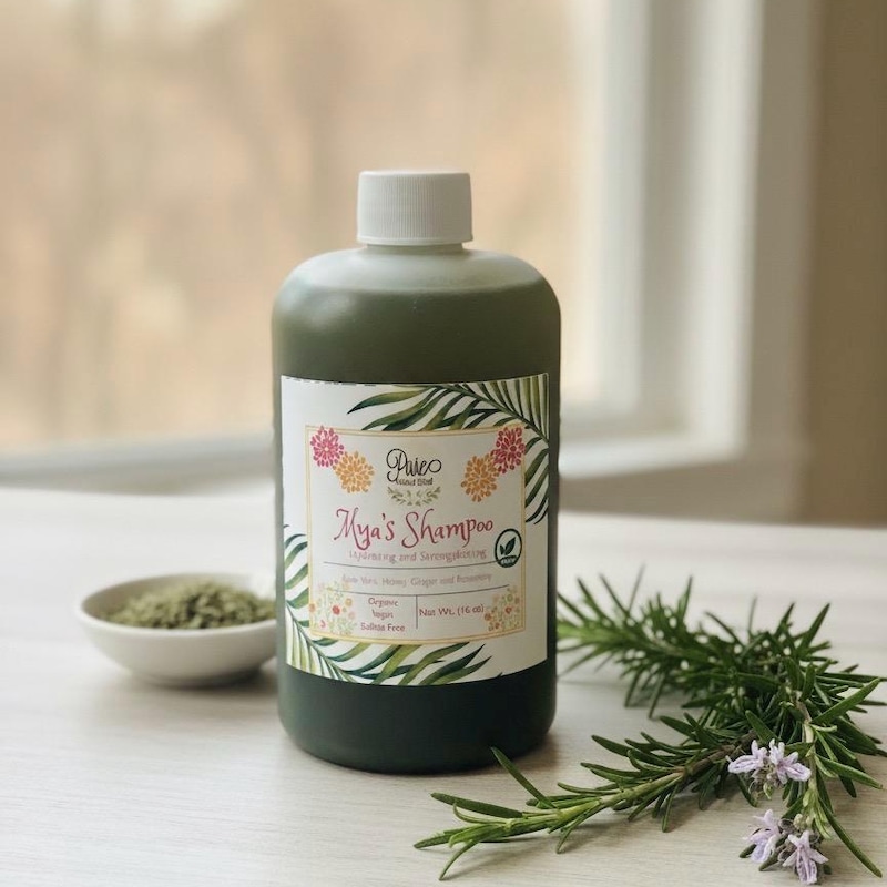Pure Natural rosemary shampoo beside fresh rosemary